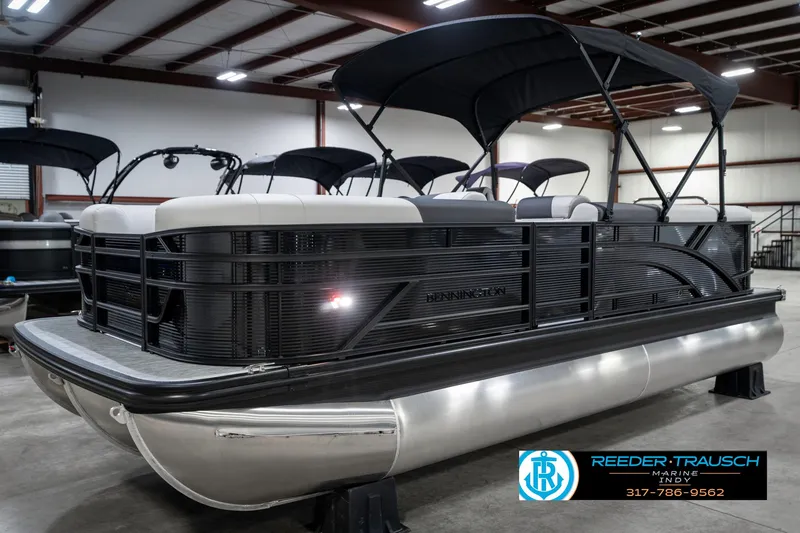 Slide: The Image of 2025 Bennington 21 SL pontoon boat in showroom with black canopy. - 3