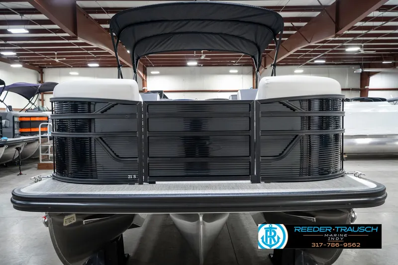 Slide: The Image of 2025 Bennington 21 SL pontoon boat in showroom, black exterior, under indoor lighting. - 5