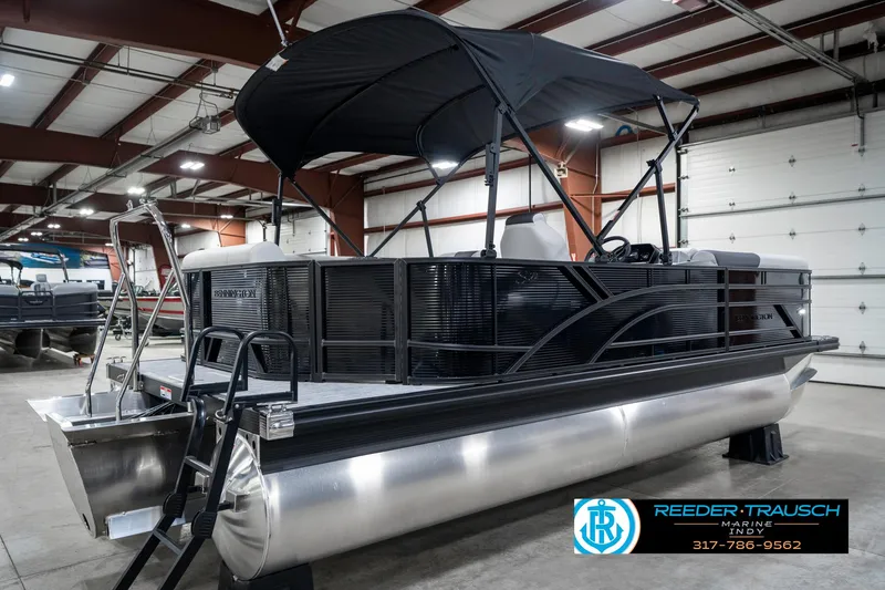 Slide: The Image of 2025 Bennington 21 SL pontoon boat in showroom with canopy and sleek design. - 8