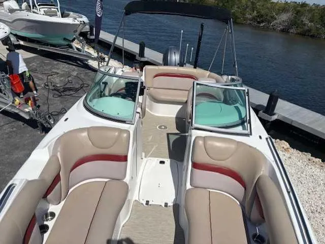 Slide: The Image of 2015 Hurricane SD 2200 DC OB boat with spacious seating, docked by a serene waterway. - 19