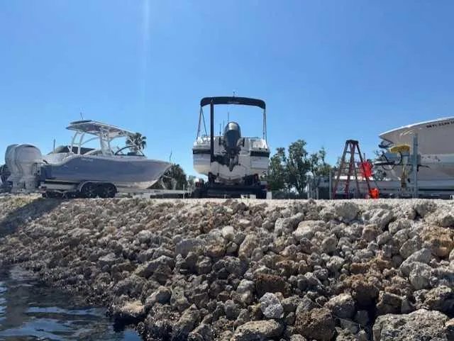 Slide: The Image of 2015 Hurricane SD 2200 DC OB boat on rocky shore, clear sky background. - 7