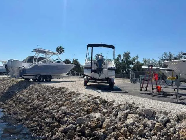 Slide: The Image of 2015 Hurricane SD 2200 DC OB boat on trailer, sunny day, rocky shoreline. - 8