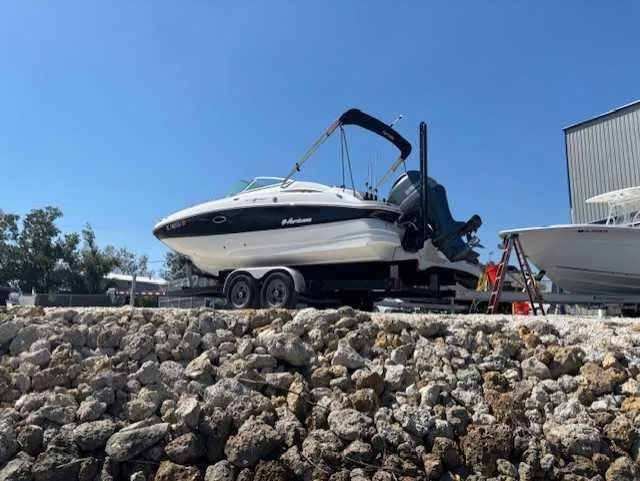 Slide: The Image of 2015 Hurricane SD 2200 DC OB boat on trailer, parked on rocky shore. - 9