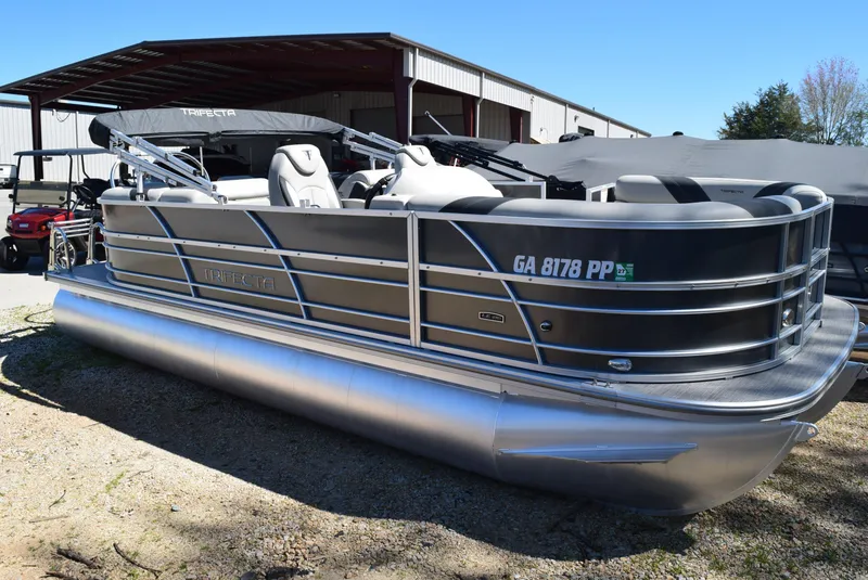 Slide: The Image of 2023 Trifecta 22RF LE 2.75 pontoon boat parked outdoors. - 0