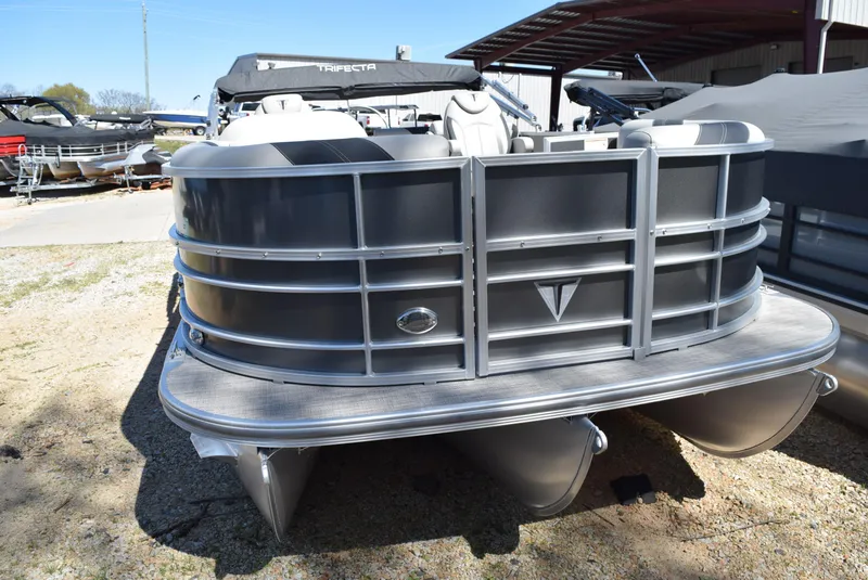 Slide: The Image of 2023 Trifecta 22RF LE 2.75 pontoon boat, front view, parked outdoors. - 2