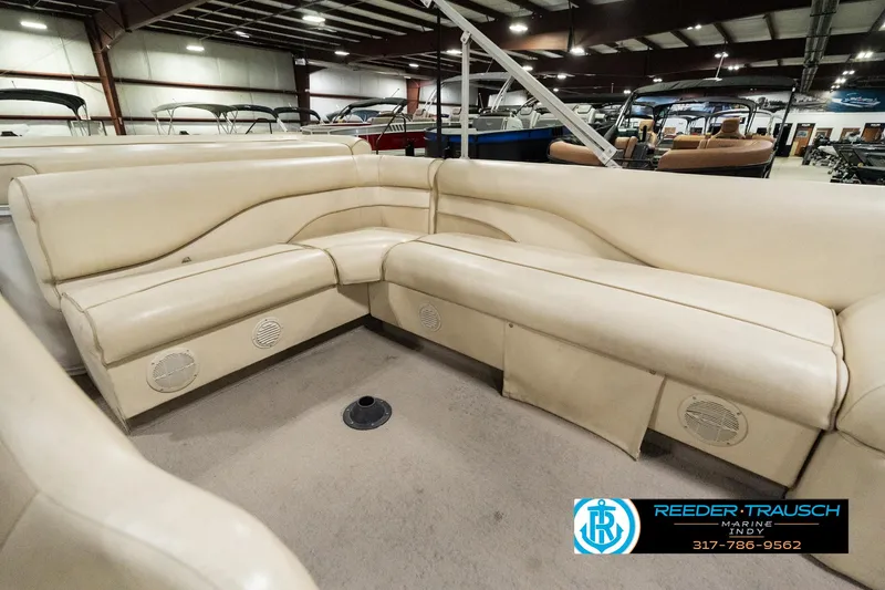 Slide: The Image of 2001 Sweetwater SW 20 RE boat interior with beige seating in a showroom. - 22