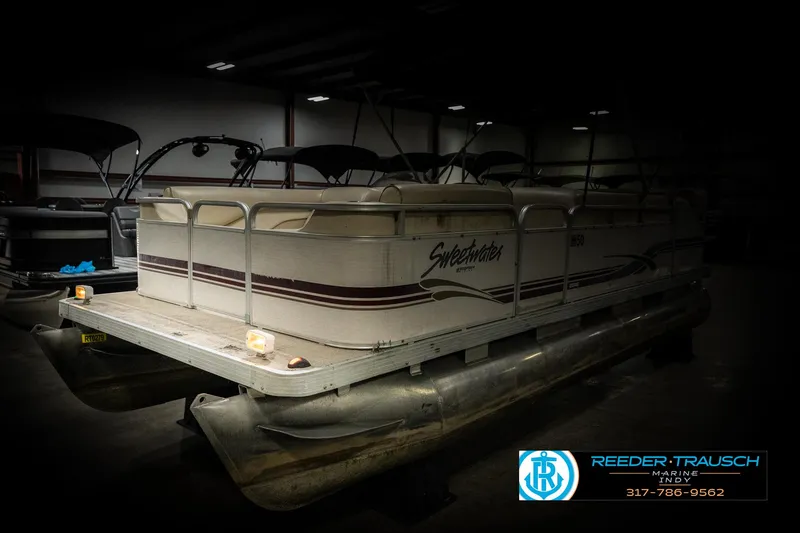 Slide: The Image of 2001 Sweetwater SW 20 RE pontoon boat in a dimly lit indoor storage. - 4