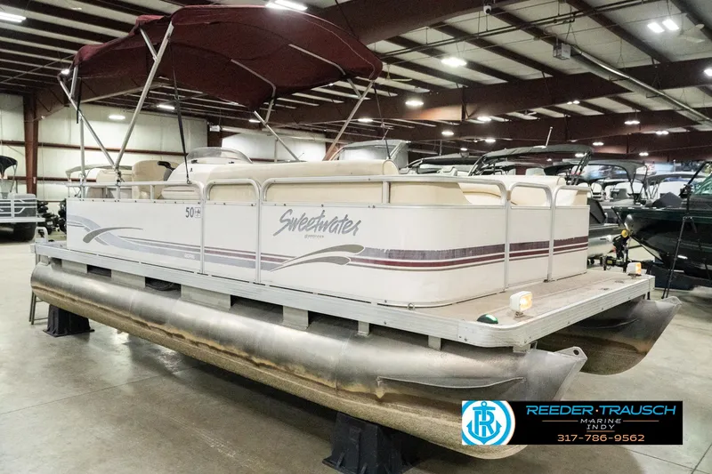 Slide: The Image of 2001 Sweetwater SW 20 RE pontoon boat with maroon canopy in indoor showroom. - 6