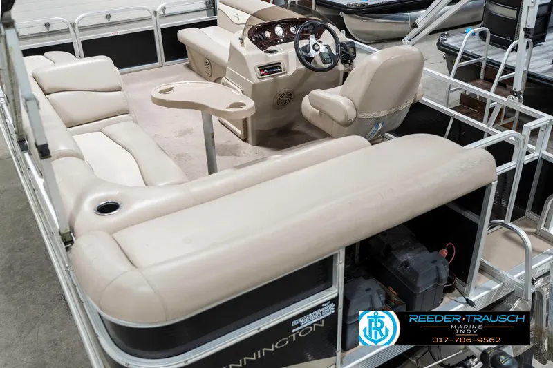 Slide: The Image of 2011 Bennington 17 Sli pontoon boat interior with beige seating and steering console. - 15