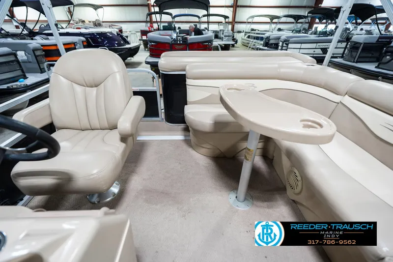 Slide: The Image of 2011 Bennington 17 Sli pontoon boat interior with beige seating and table. - 17