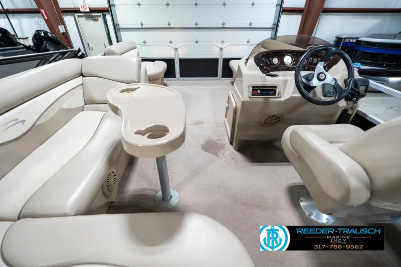 Slide: The Image of 2011 Bennington 17 Sli pontoon boat interior with beige seating and steering console. - 18