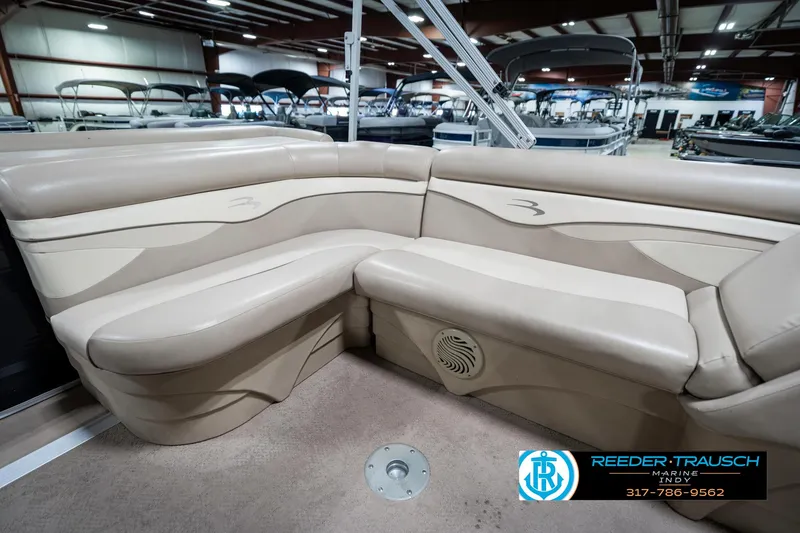 Slide: The Image of 2011 Bennington 17 Sli pontoon boat interior with beige seating in showroom. - 24