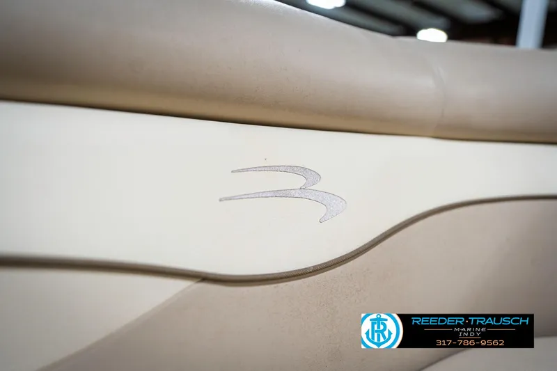 Slide: The Image of 2011 Bennington 17 Sli boat interior with logo detail, featuring beige upholstery. - 38