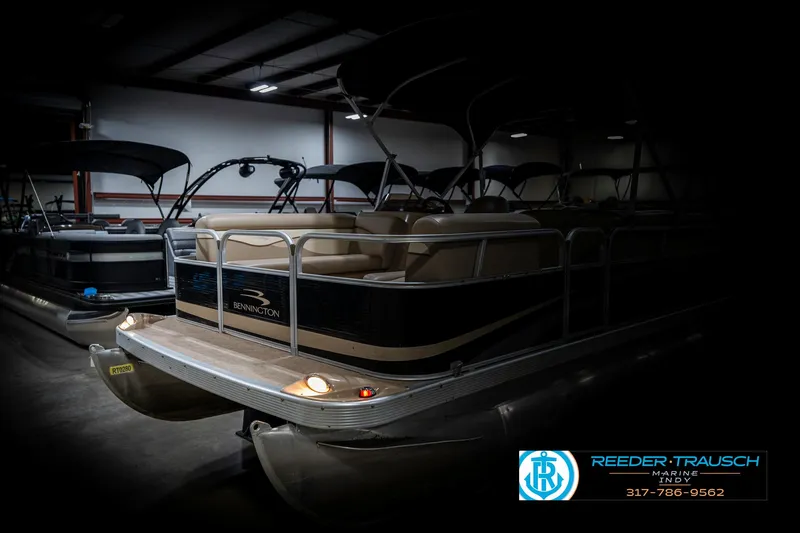 Slide: The Image of 2011 Bennington 17 Sli pontoon boat in a dimly lit showroom. - 4