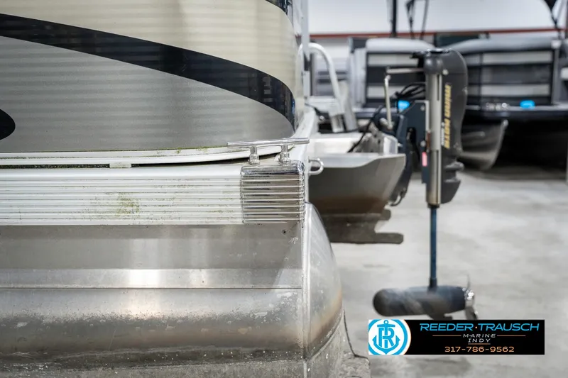 Slide: The Image of 2011 Bennington 17 Sli pontoon boat in storage, featuring aluminum pontoons and motor. - 44