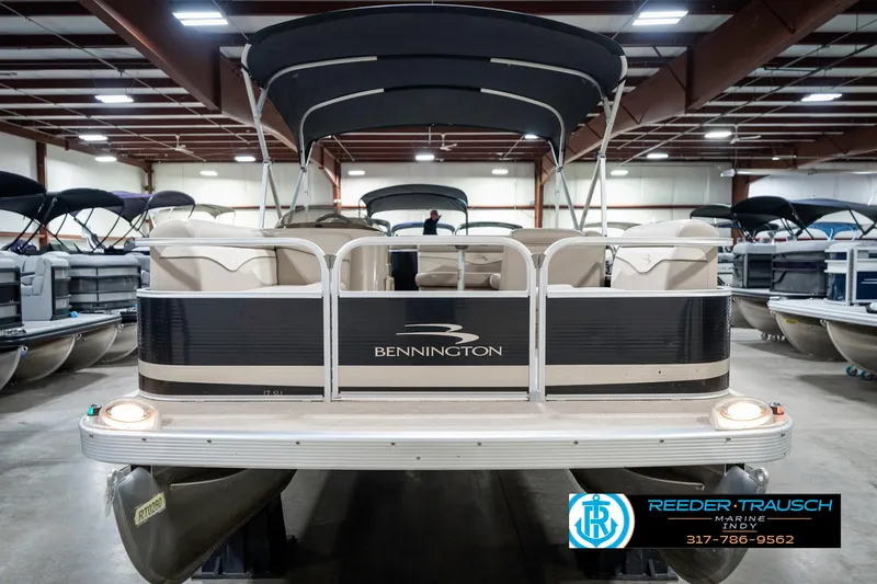 Slide: The Image of 2011 Bennington 17 Sli pontoon boat in showroom, featuring canopy and seating. - 5