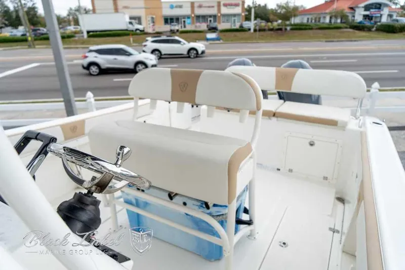 Slide: The Image of 2017 Century 2600 boat interior with steering wheel and seating, parked near a busy road. - 10