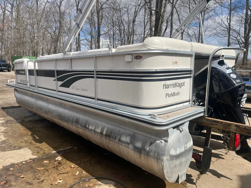 Slide: The Image of 2000 Harris-Kayot 220 Super Sunliner pontoon boat on dry land, surrounded by trees. - 2