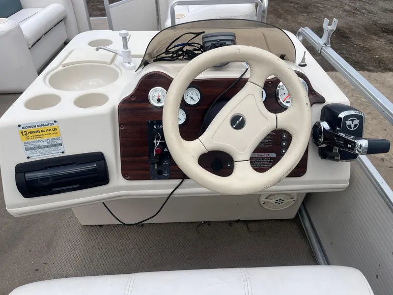 Slide: The Image of 2000 Harris-Kayot 220 Super Sunliner boat dashboard with steering wheel and gauges. - 9