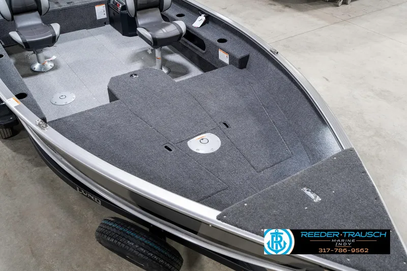 Slide: The Image of 2025 Lund 1775 Pro Guide boat interior with gray carpet and seating, displayed indoors. - 11
