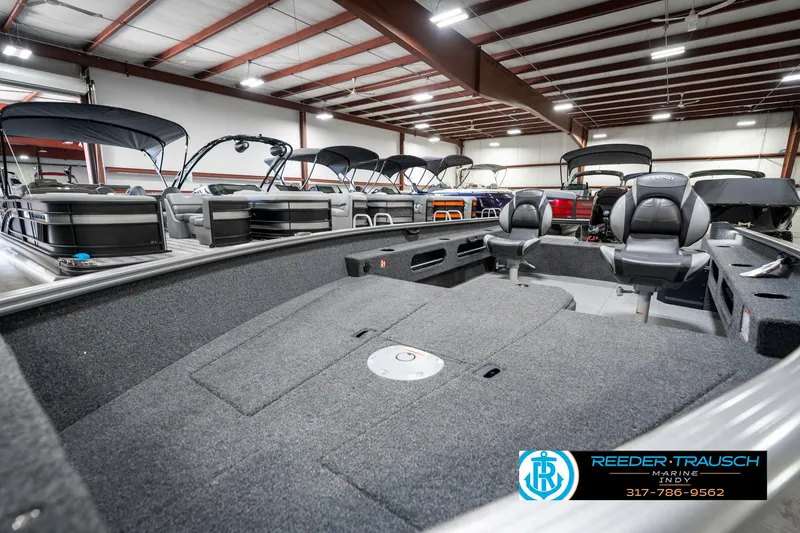Slide: The Image of 2025 Lund 1775 Pro Guide boat interior in showroom, featuring spacious seating and modern design. - 20