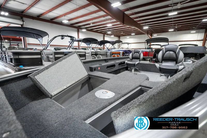 Slide: The Image of 2025 Lund 1775 Pro Guide boat interior in showroom with multiple boats displayed. - 21