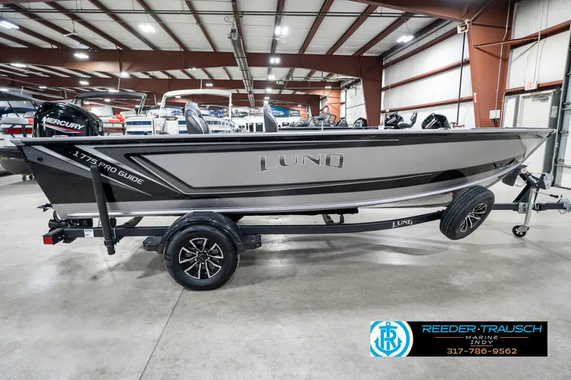 Slide: The Image of 2025 Lund 1775 Pro Guide boat on trailer in showroom, side view. - 5