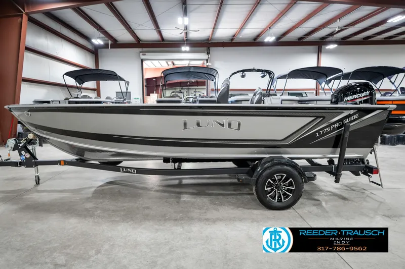 Slide: The Image of 2025 Lund 1775 Pro Guide boat in showroom, side view, on trailer. - 9