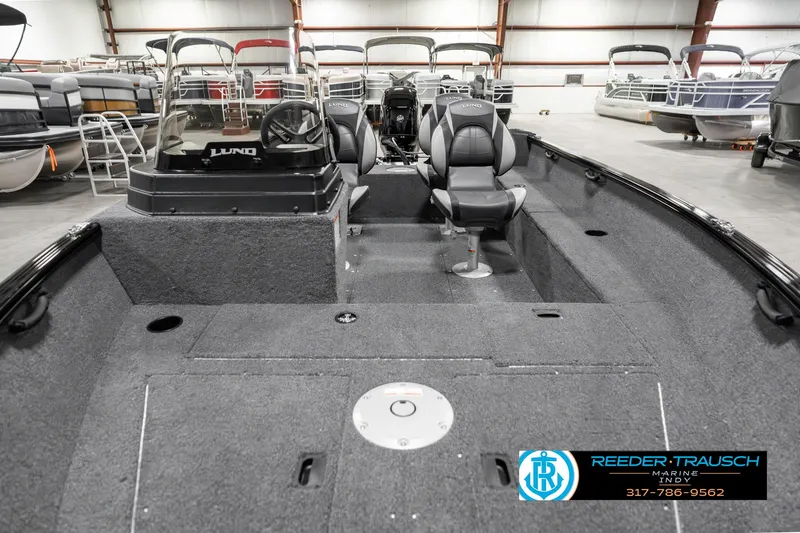 Slide: The Image of 2025 Lund 1650 Rebel XL SS boat interior with seating and steering console in showroom. - 17