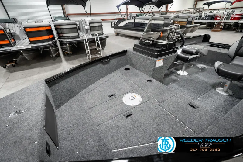 Slide: The Image of 2025 Lund 1650 Rebel XL SS boat interior with seating and control console in showroom. - 20
