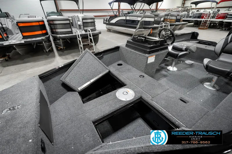Slide: The Image of 2025 Lund 1650 Rebel XL SS boat interior with open storage compartments in showroom. - 21