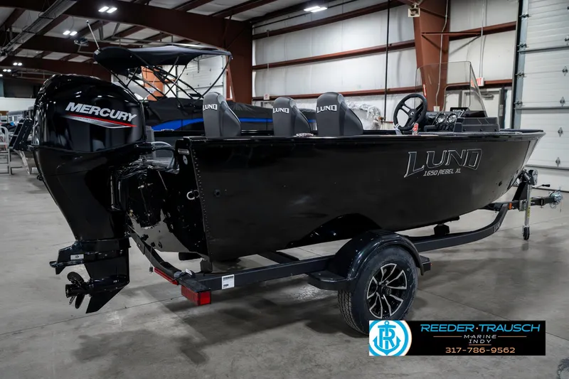 Slide: The Image of 2025 Lund 1650 Rebel XL SS boat with Mercury engine in a warehouse setting. - 6