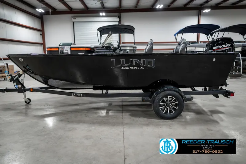 Slide: The Image of 2025 Lund 1650 Rebel XL SS boat in a warehouse setting. - 9