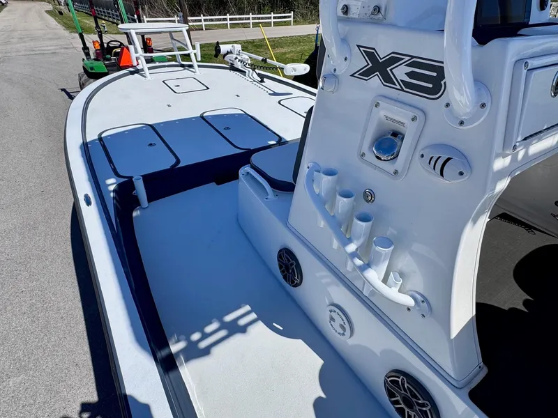 Slide: The Image of 2024 Shallow Sport 25 X3 boat interior with rod holders and storage compartments. - 11