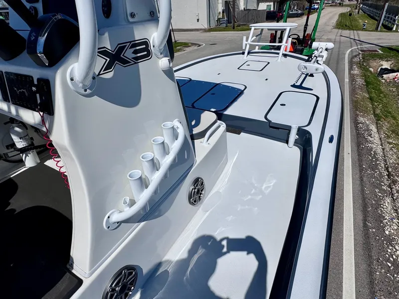 Slide: The Image of 2024 Shallow Sport 25 X3 boat deck with rod holders and storage compartments. - 13