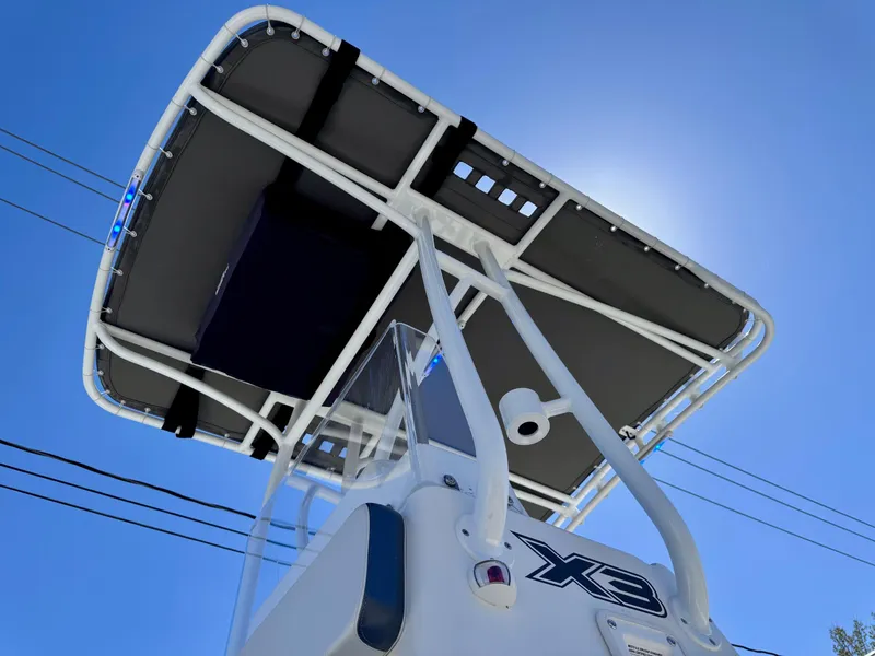 Slide: The Image of 2024 Shallow Sport 25 X3 boat with T-top against a clear blue sky. - 18