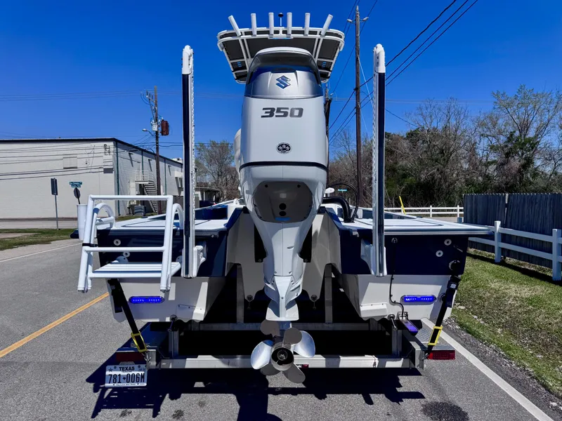 Slide: The Image of 2024 Shallow Sport 25 X3 boat with Suzuki 350 engine, rear view on street. - 3