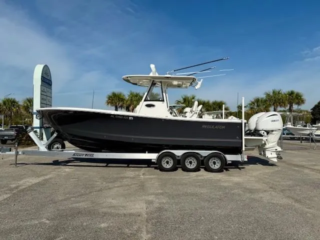 Slide: The Image of 2023 Regulator 28 boat on trailer, parked outdoors under clear blue sky. - 1