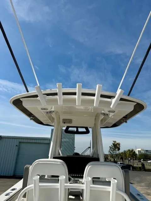 Slide: The Image of 2023 Regulator 28 boat with rod holders, clear sky background. - 13