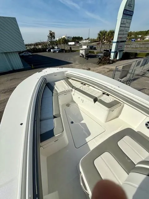 Slide: The Image of 2023 Regulator 28 boat with spacious seating and modern design, docked at a marina. - 18