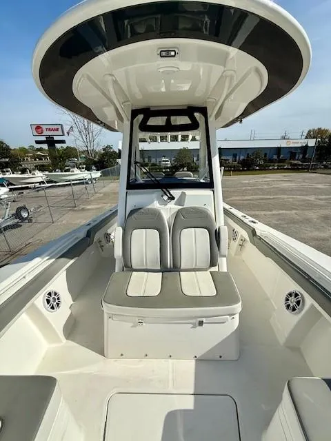 Slide: The Image of 2023 Regulator 28 boat interior with seating and console, displayed outdoors. - 19