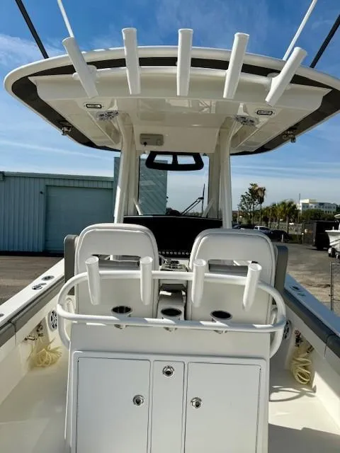 Slide: The Image of 2023 Regulator 28 boat with rod holders and dual seating, docked under clear skies. - 23