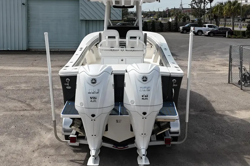 Slide: The Image of 2023 Regulator 28 boat with dual Yamaha V6 outboard engines, parked outdoors. - 28
