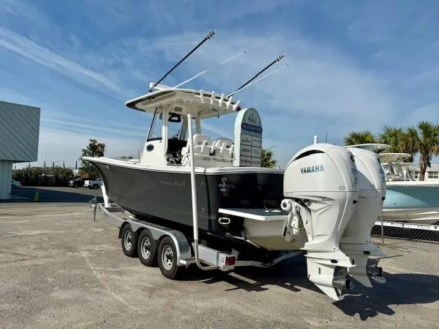 Slide: The Image of 2023 Regulator 28 boat with dual Yamaha engines on a trailer, parked outdoors. - 3