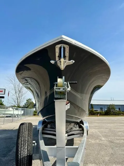 Slide: The Image of 2023 Regulator 28 boat on trailer, viewed from the front under a clear blue sky. - 7