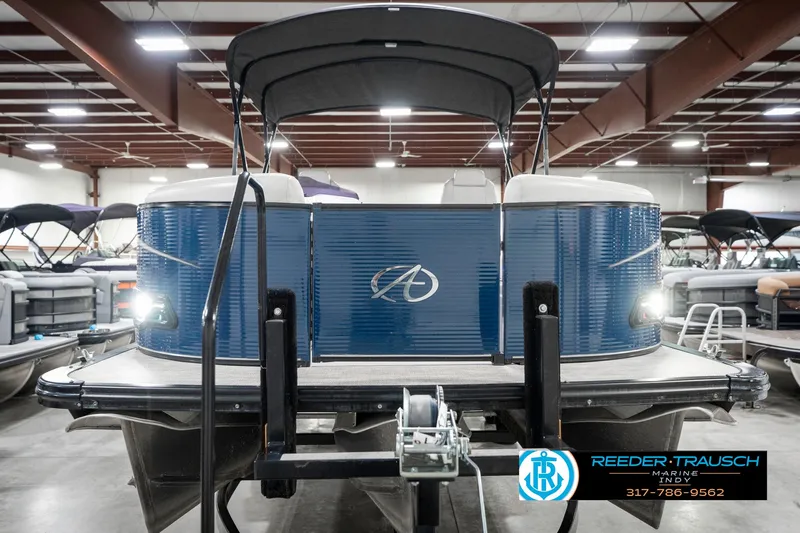 Slide: The Image of 2020 Avalon 2485 pontoon boat in showroom, rear view with blue exterior. - 5