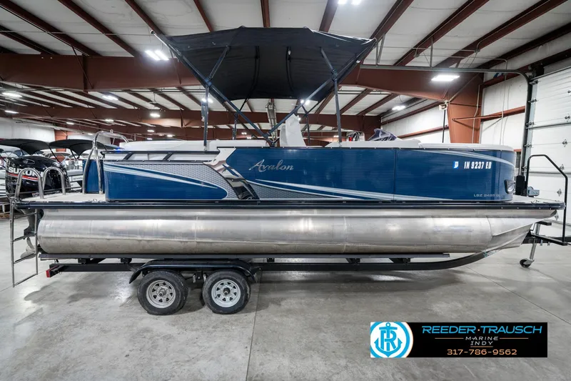 Slide: The Image of 2020 Avalon 2485 pontoon boat on trailer in indoor showroom. - 7