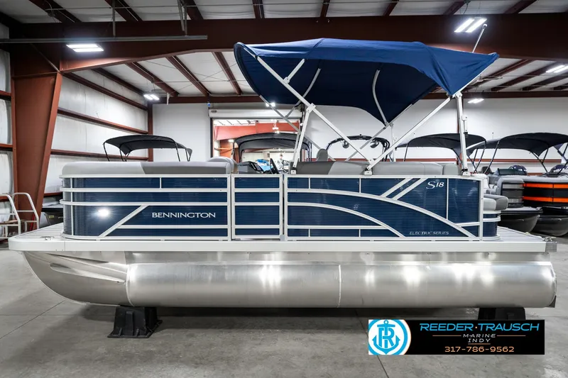 Slide: The Image of 2025 Bennington 18 SLJ pontoon boat with blue canopy in showroom. - 11