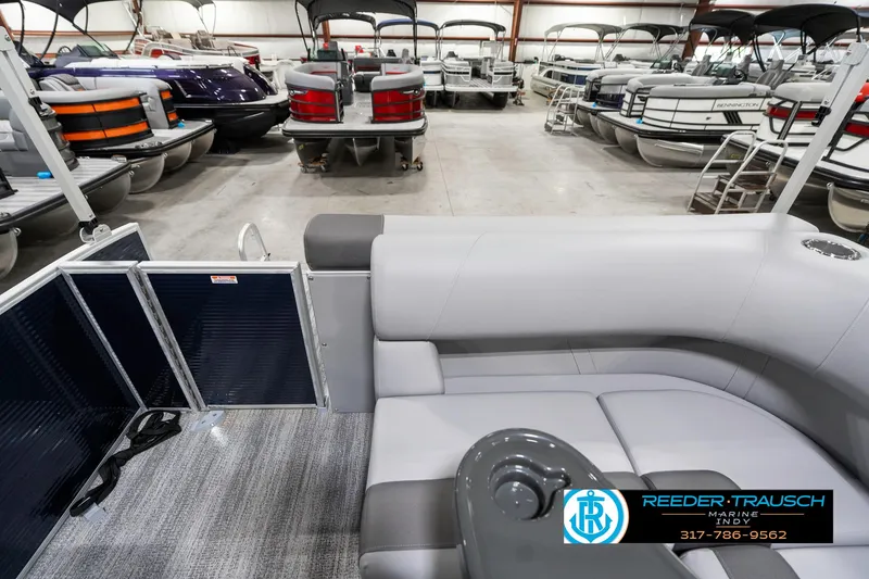 Slide: The Image of 2025 Bennington 18 SLJ pontoon boat interior in showroom with multiple boats in background. - 18