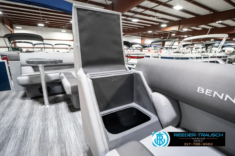 Slide: The Image of 2025 Bennington 18 SLJ boat interior with storage compartment open, showcasing seating and table. - 24